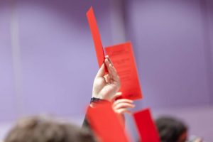 Eine Hand mit einer roten Abstimmungskarte